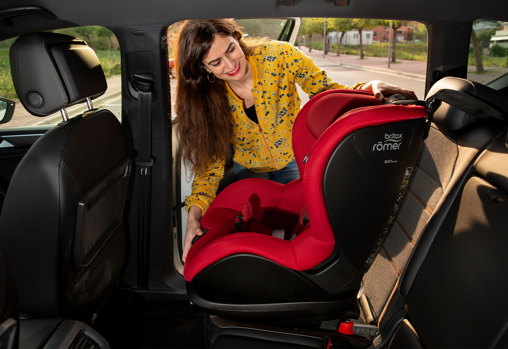 Woman installing a booster car seat 