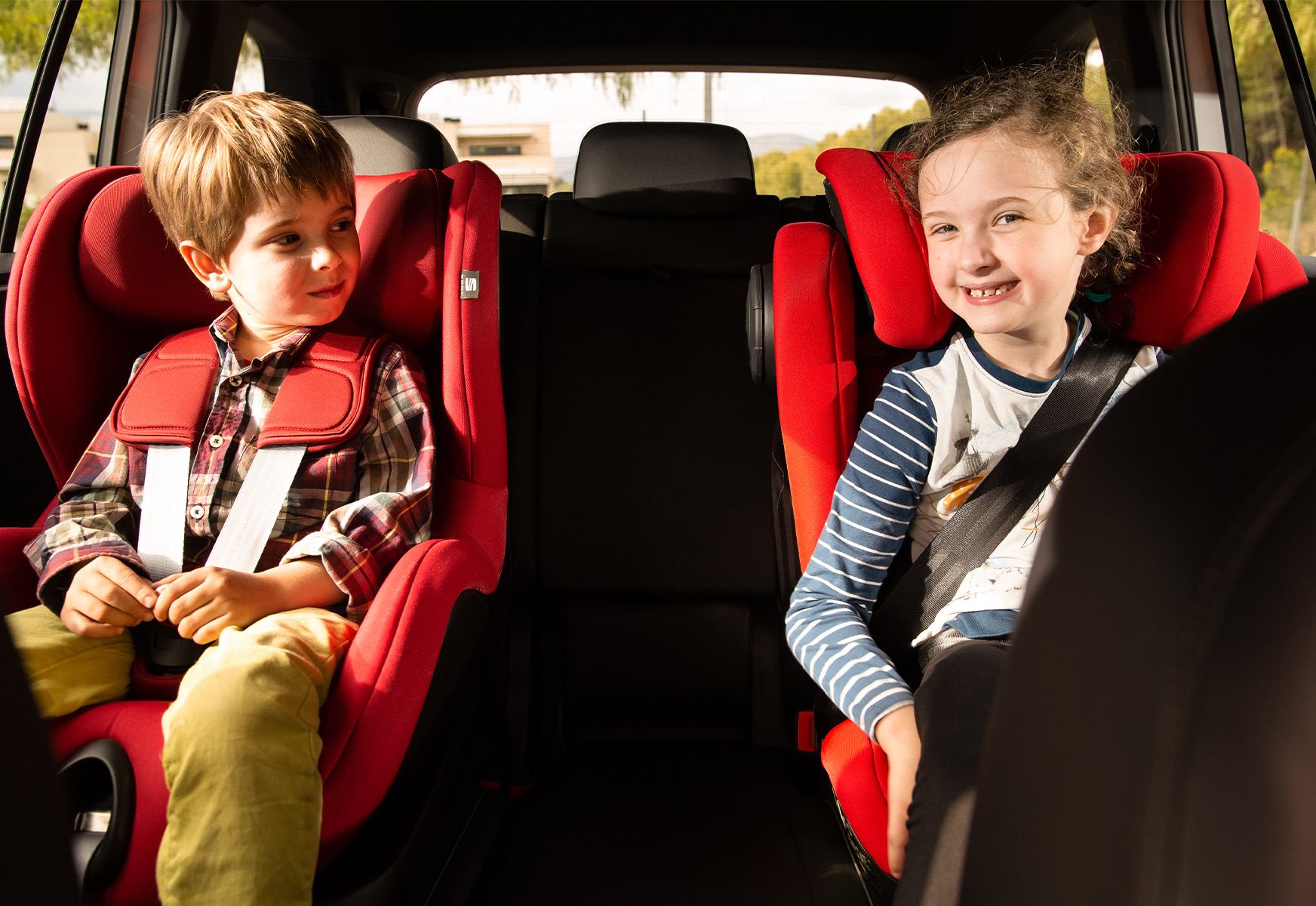 Two young children in booster car seats