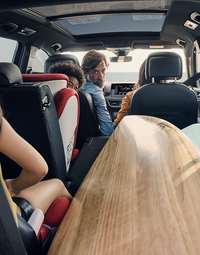 SEAT Tarraco interior view with a family inside with a surfboard 
