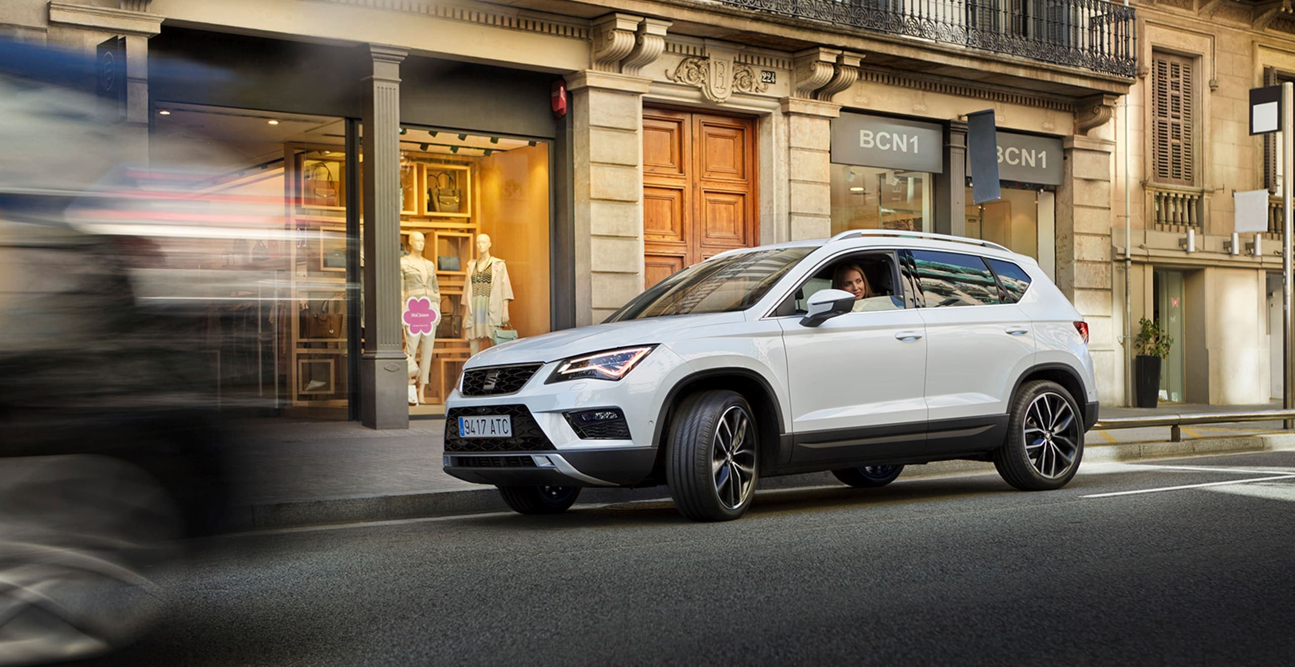 SEAT new car services maintenance insurance –  SEAT Ateca SUV side view driving on city street